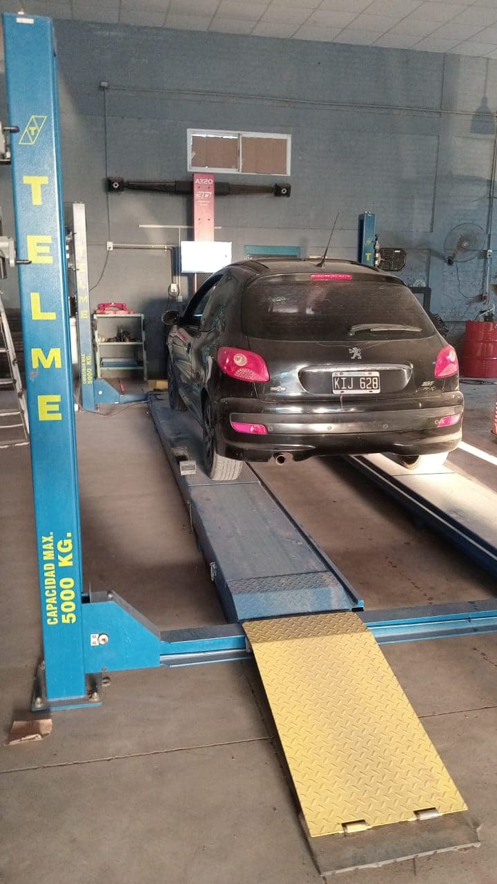 Auto en elevador dentro del taller de Gomeria Pato Lucas